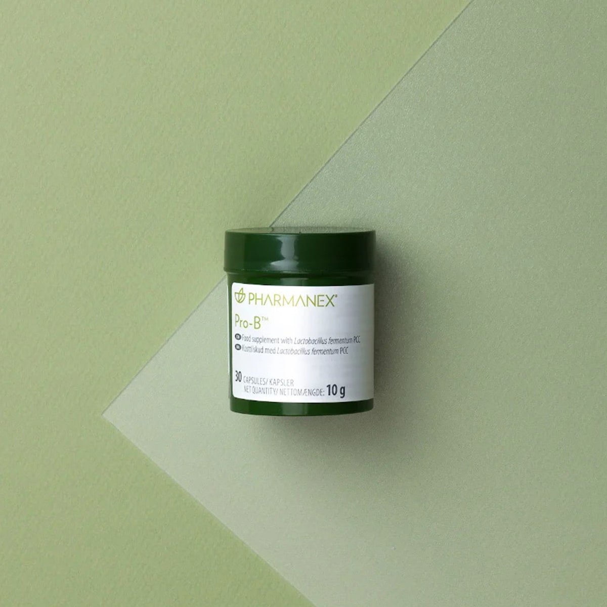 NuSkin Pharmanex Pro-B Kapseldose (enthält 30 Kapseln, Nettogewicht: 10 g) liegt geschlossen auf mintgrüner glatter Oberfläche.