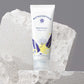 Nutricentials Brighter Day Exfoliant Scrub Tube (100ml) steht auf kleinem weißen "Podest" aus Stein.