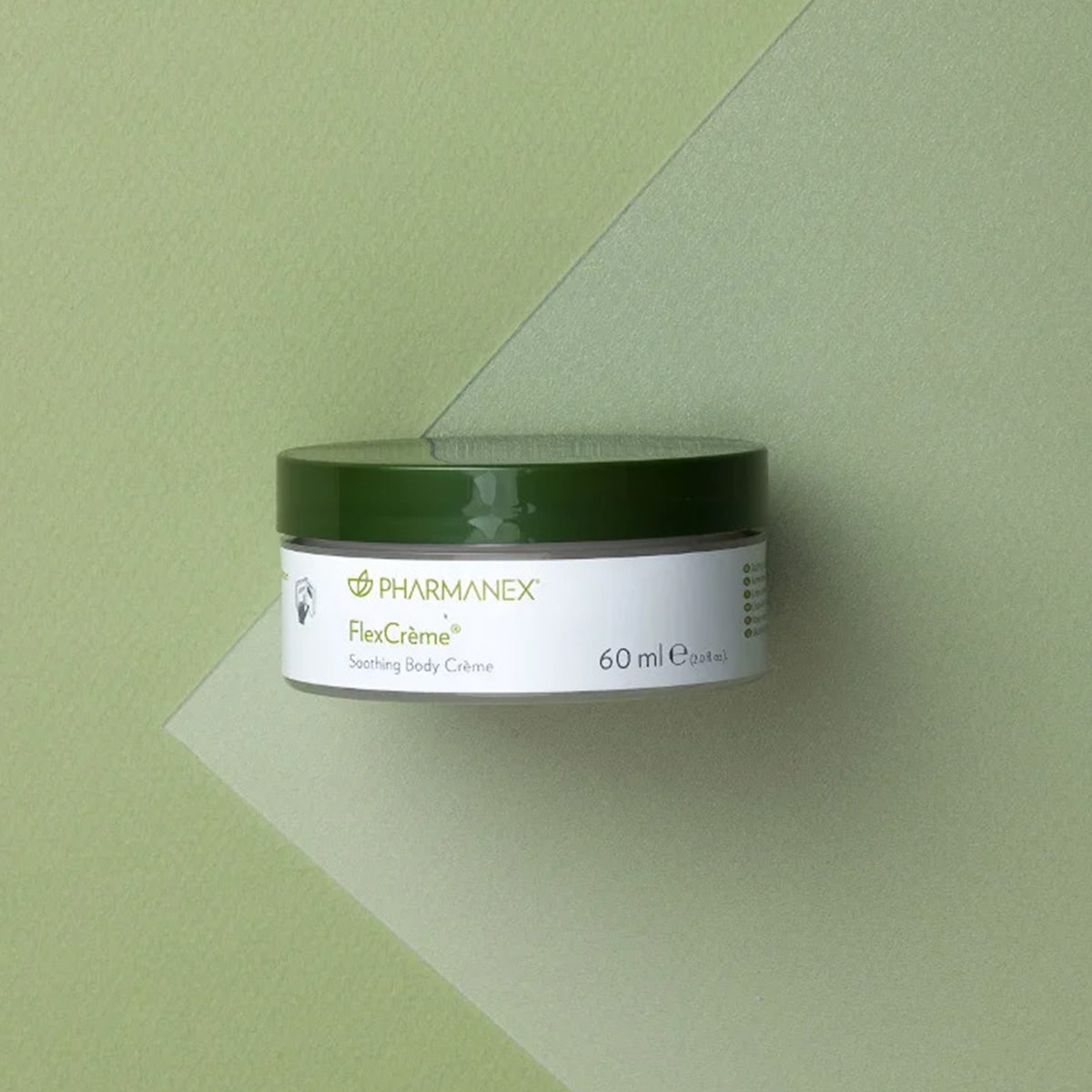 Pharmanex Flex Creme von NuSkin liegt geschlossen auf olivfarbener Oberfläche.