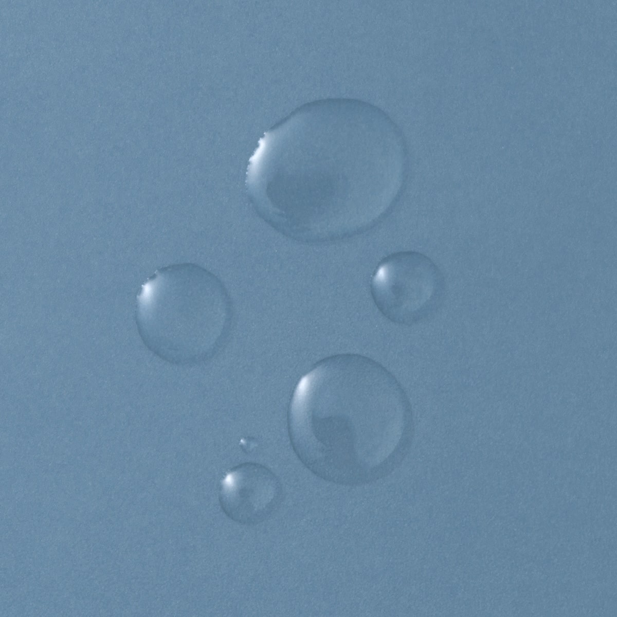 Konsistenz Probe: auf eine glatte, blaue Oberfläche wurden mehrere Tropfen der flüssig-klaren Priming Solution gegeben. 