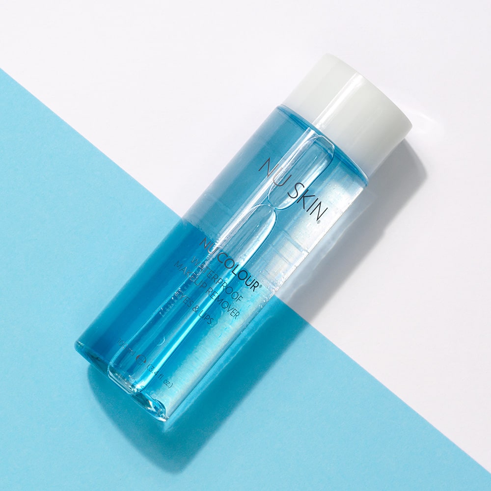 Nu Colour Waterproof Makeup Remover von NuSkin liegt geschlossen auf glatter blau-weißer Oberfläche.
