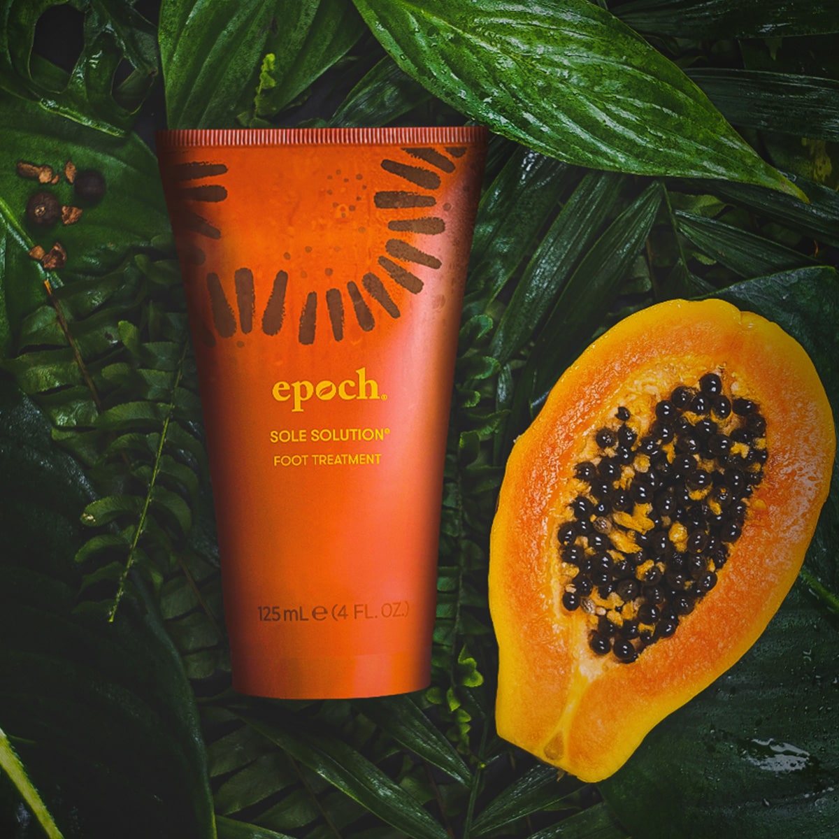Epoch Sole Solution von NuSkin (125ml) liegt zusammen mit aufgeschnittener Papaya auf dunkelgrünem feuchten Farn.